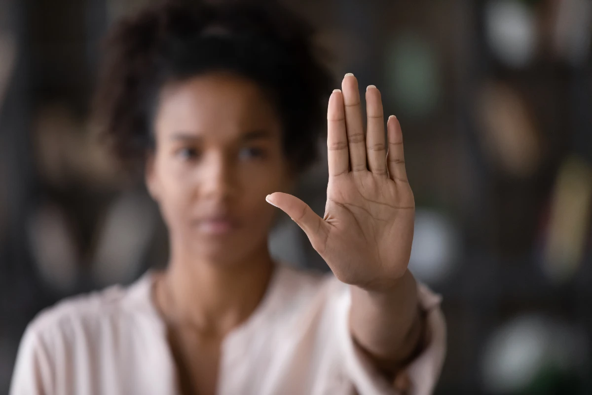 Image of a person holding there hand up in the stop position to reflect Zero Tolerance